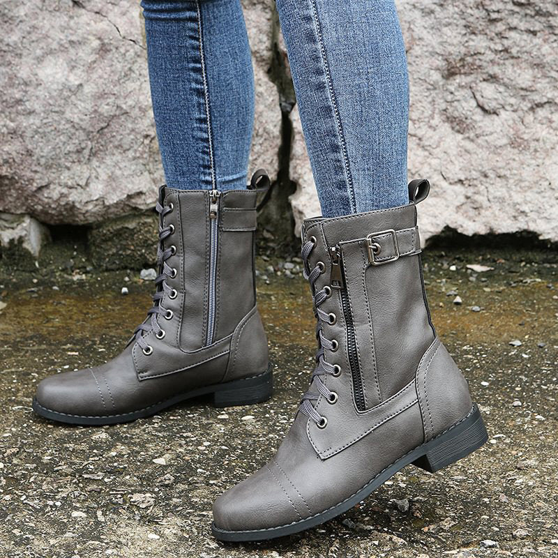 Model wearing women's combat boots with side zip, paired with jeans, highlighting the ankle height and fit.