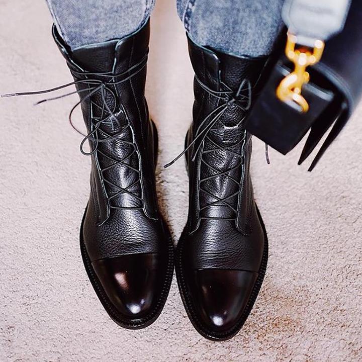 Close-up of women's lace-up leather ankle boots showing detailed stitching & durable sole.