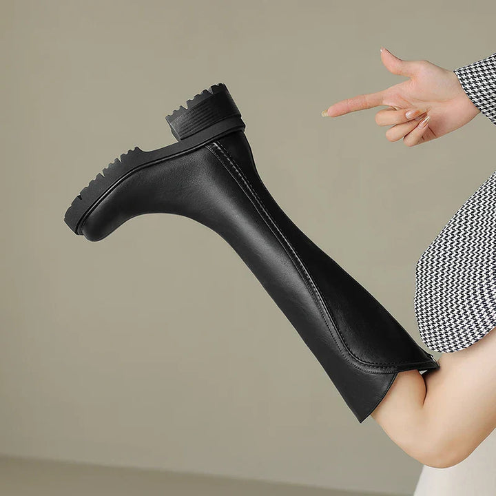 Pair of women's orthopedic leather boots, black, showing sturdy sole and comfortable design
