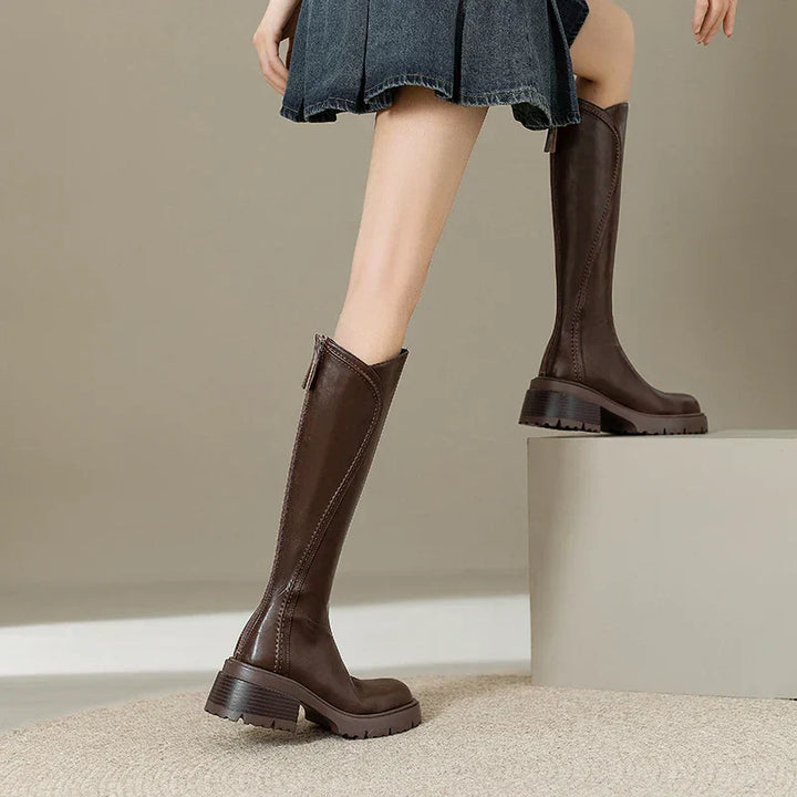 Lady wearing women's orthopedic brown leather knee-high boots, outdoor setting, fall style