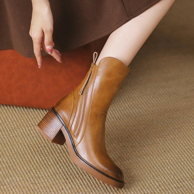 Close-up of women's leather ankle boots, showcasing the silver zip and quality leather texture
