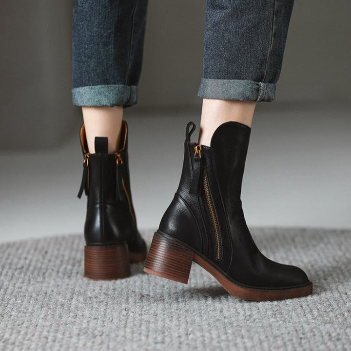 Detail shot of the block heel on women's leather zip ankle boots, highlighting stability and design