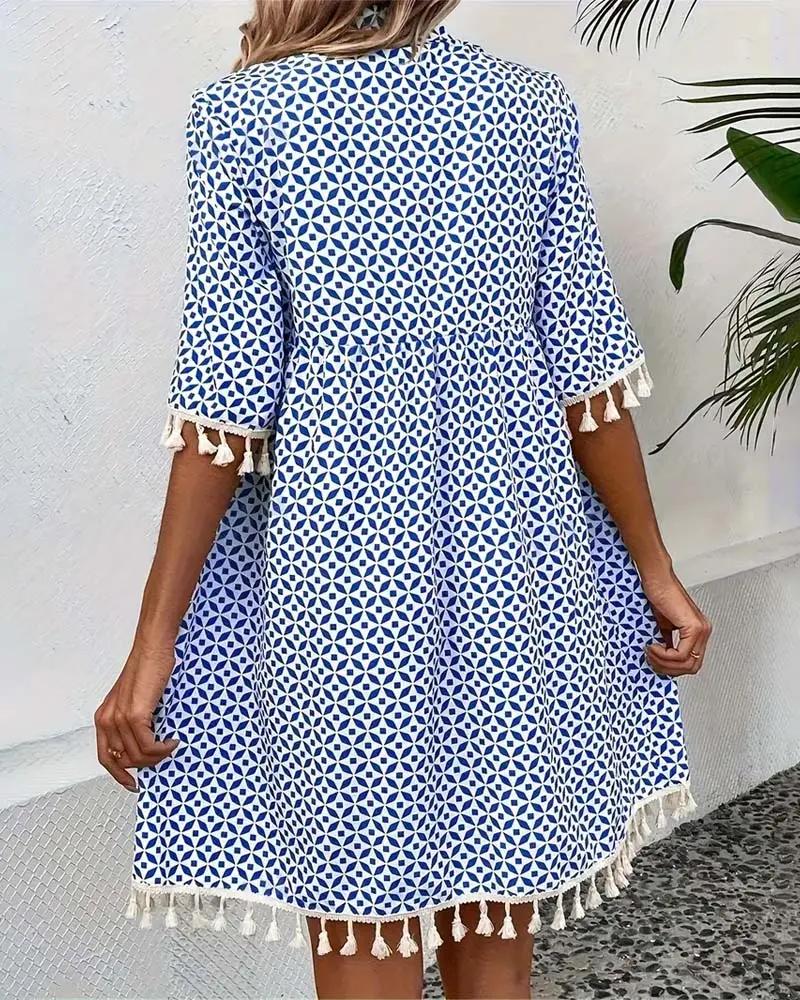 Trendy women's summer dress: blue boho mini tunic with a vibrant geometric pattern and chic tassel trim.