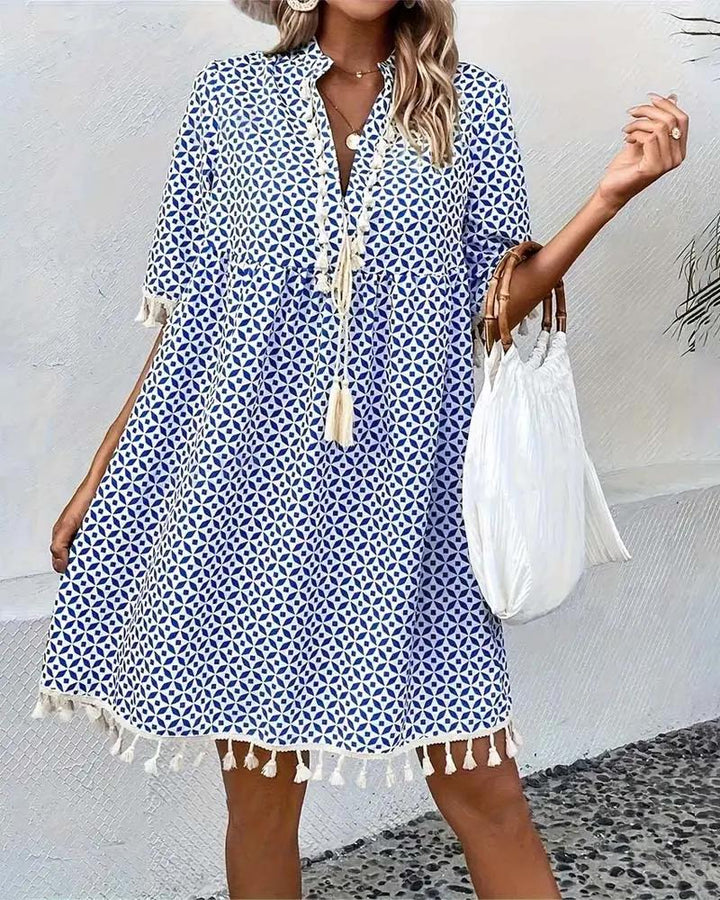Flowy blue geometric print boho mini dress, V-neck design with tassels, great for women's casual outings.