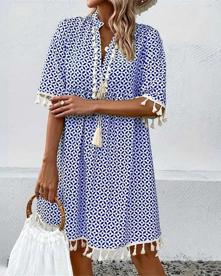 Eye-catching blue boho mini tunic dress for women, showcasing a bold geometric print and fun tassel details.