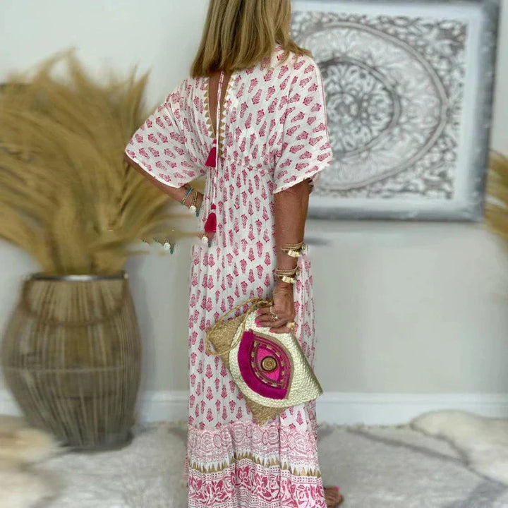 Relaxed fit women's maxi dress in vibrant boho print. Features a stylish v-neck and short sleeves for summer.
