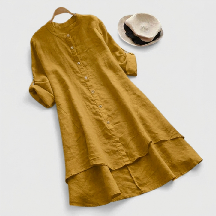 Women's button-down shirt dress with stylish layered hem. Long sleeve midi perfect for versatile, all-season casual wear.