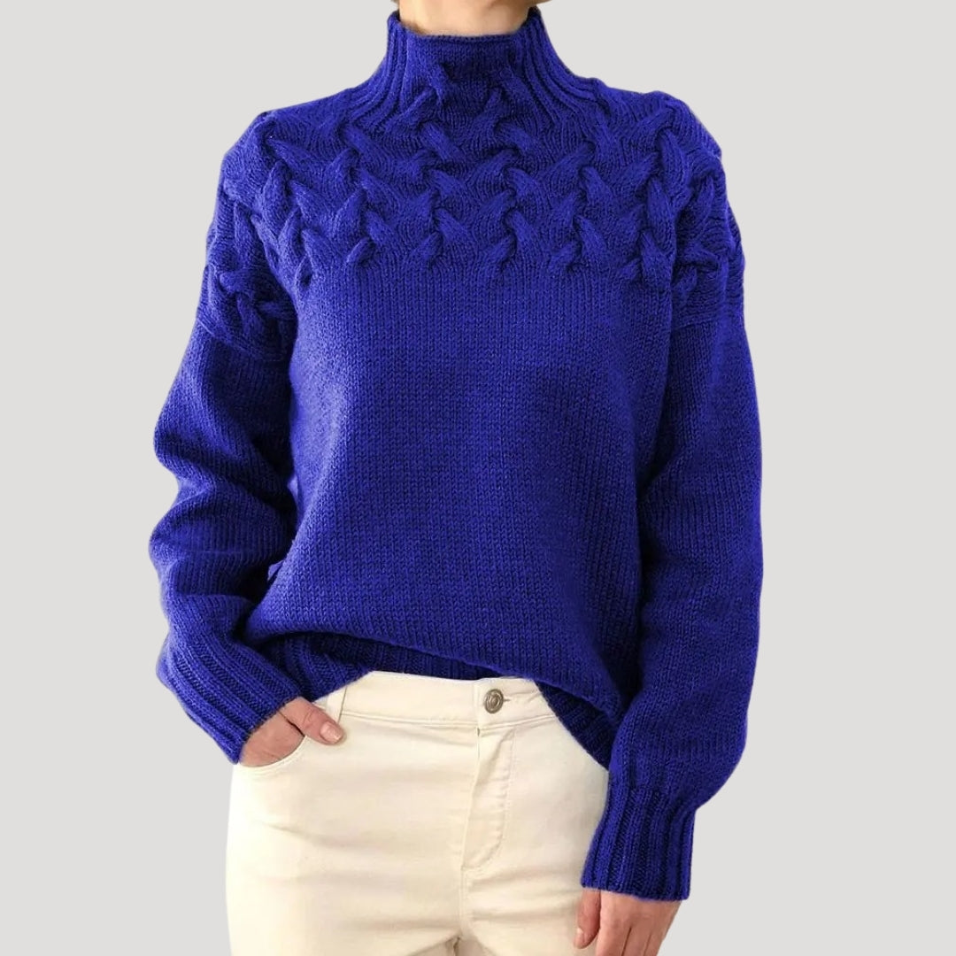 Close-up of a women's ivory cable knit high-neck sweater, showcasing intricate knit pattern and warmth.