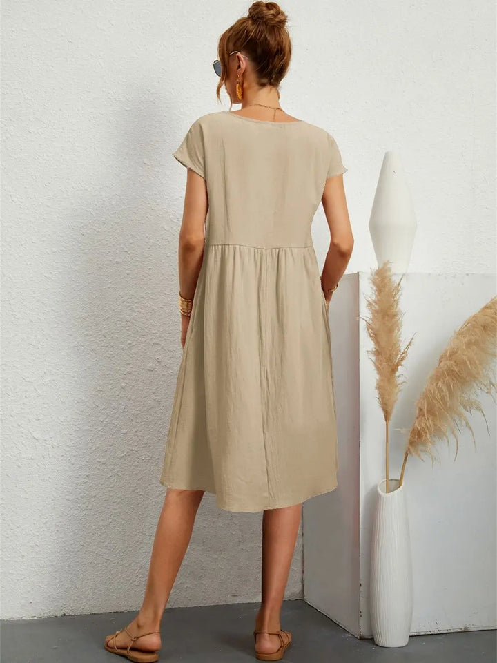 Tiered women's midi dress with short sleeves and practical pockets, ideal for a relaxed, comfortable look.
