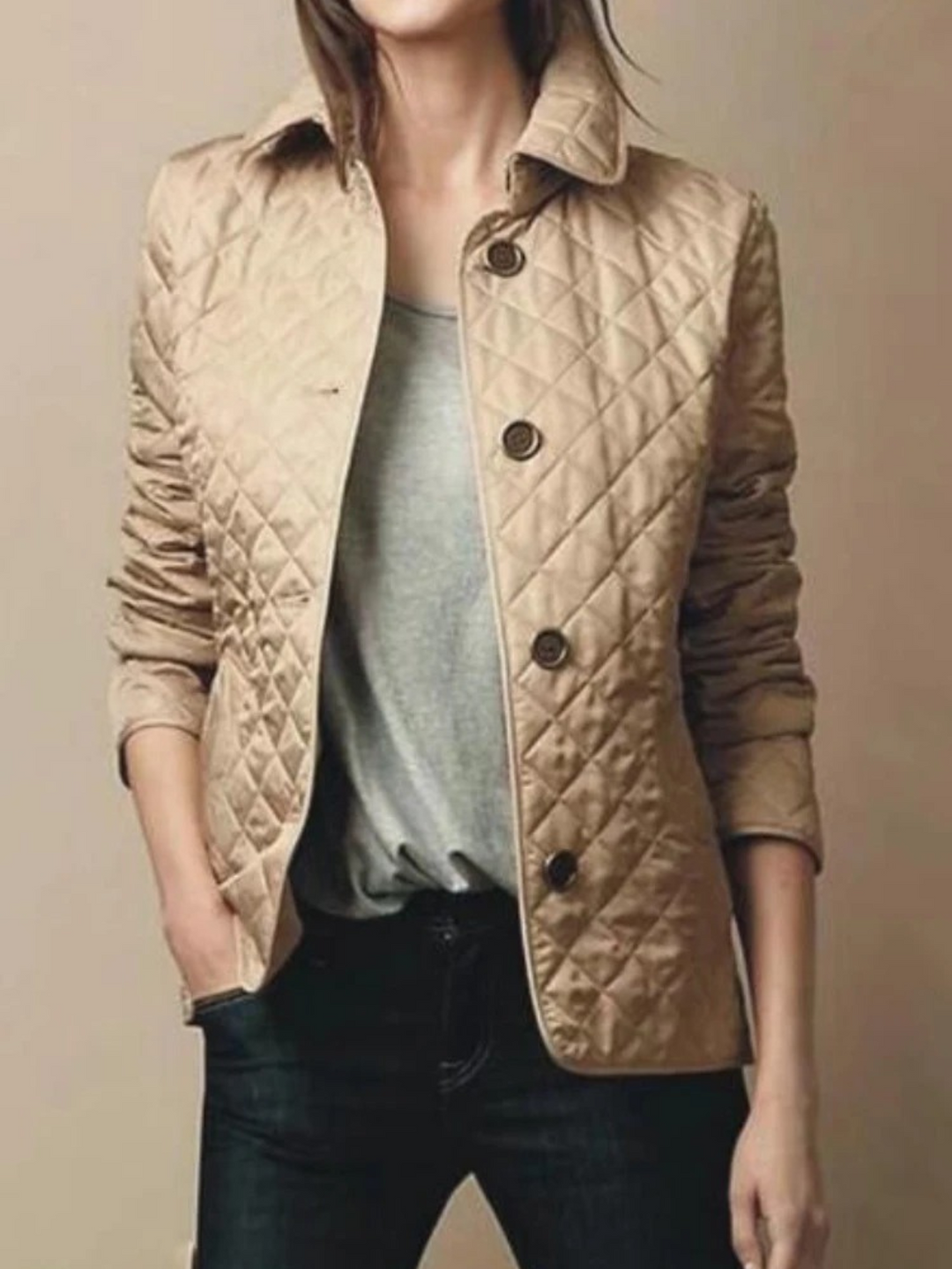 Warm women's quilted winter jacket for casual outerwear. Features a turned-down collar and snap button closure.
