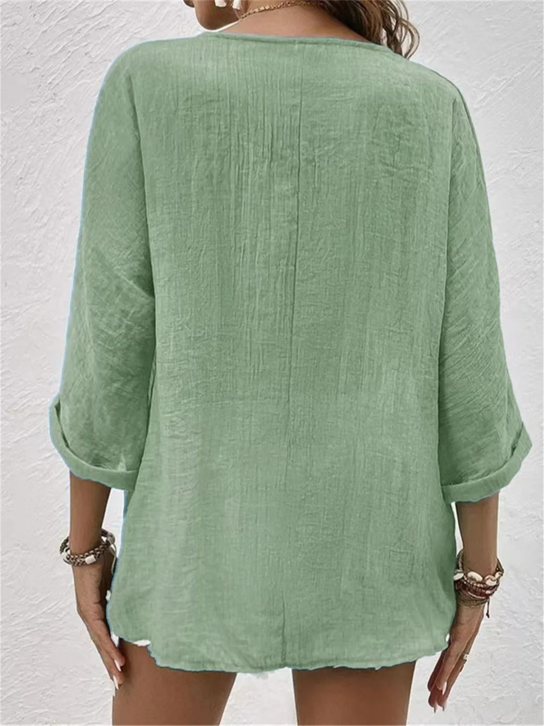 Stylish women's V-neck three-quarter sleeve button-front top for versatile casual wear.