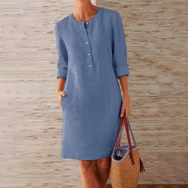 Comfortable women's shift dress featuring a button-front, 3/4 sleeves, and practical side pockets.