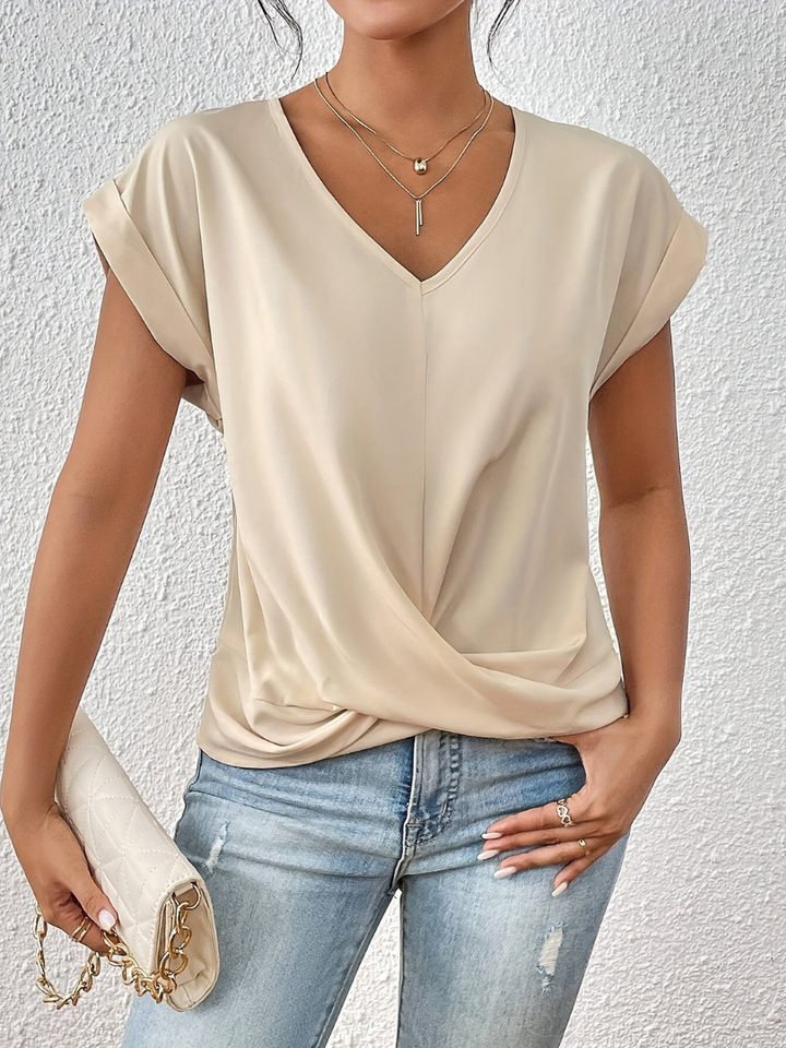 Polished women's apparel: elegant short sleeve V-neck blouse with a trendy twist-front detail. Versatile chic.