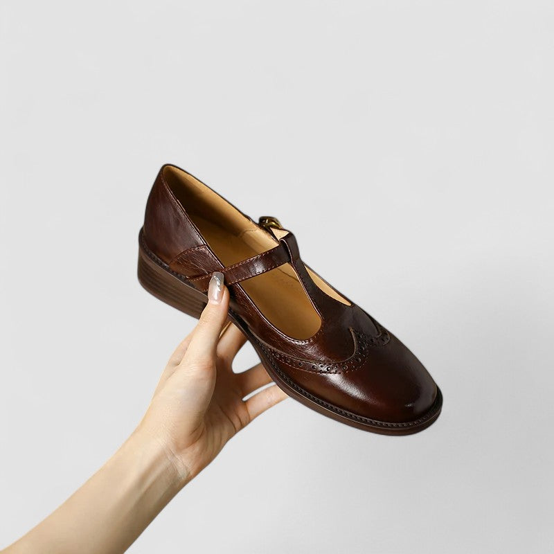 Women's black mary jane flats on a white background, classic style with buckle strap