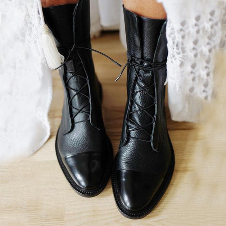 Stylish women's mid-calf combat boots, black leather with lace-up front, perfect for casual outfits.