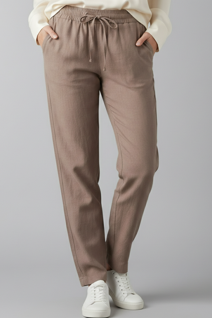 Women's casual pants with elastic waist, side pockets, tapered leg, designed for comfort & style.