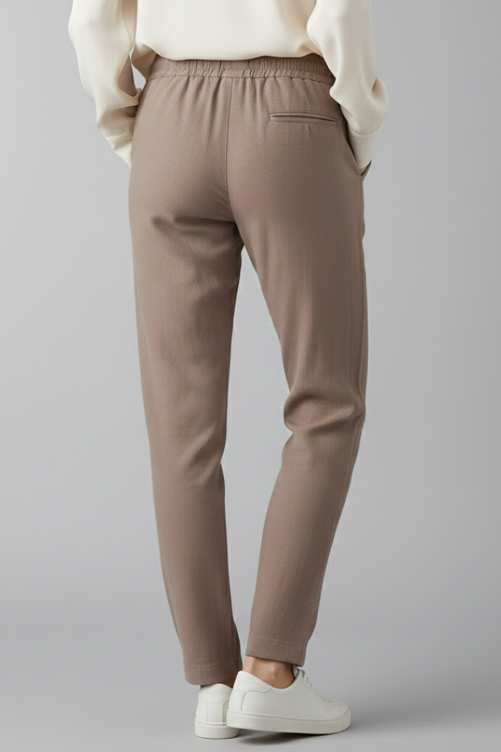 Dynamic shot of woman in women's casual trousers with elastic waist, side pockets, tapered leg.
