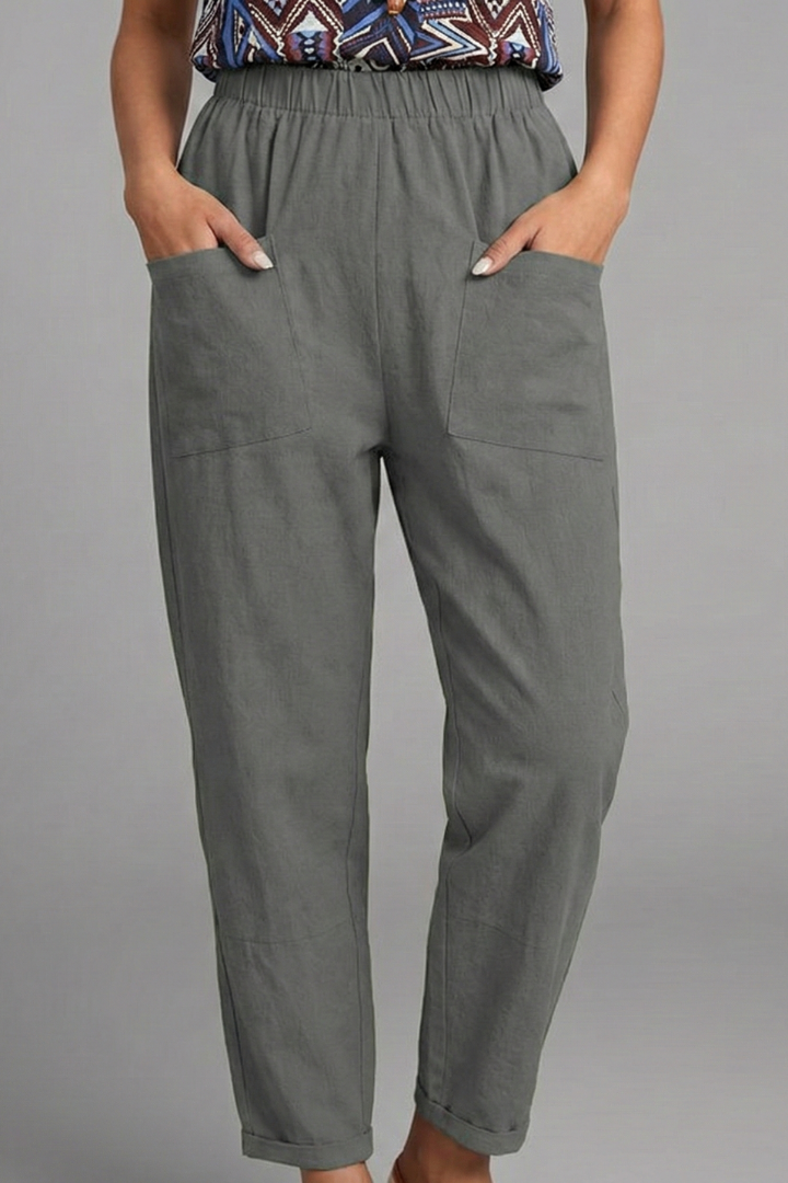 Back view: Women's casual pants showcasing elastic waist & flattering tapered ankle-length cut.