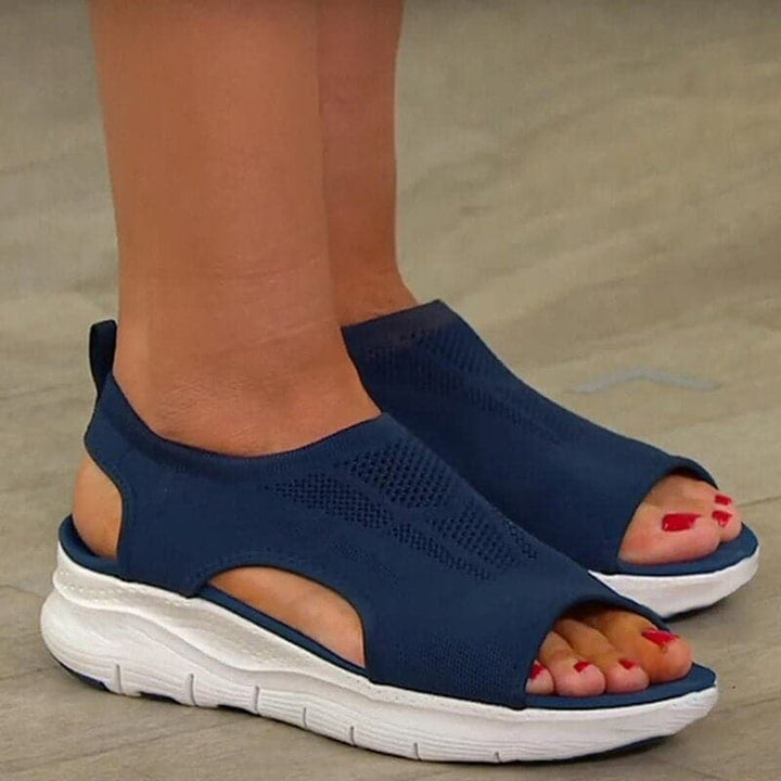 Stylish flat open-toe sandals for women in a neutral color, perfect for spring fashion.