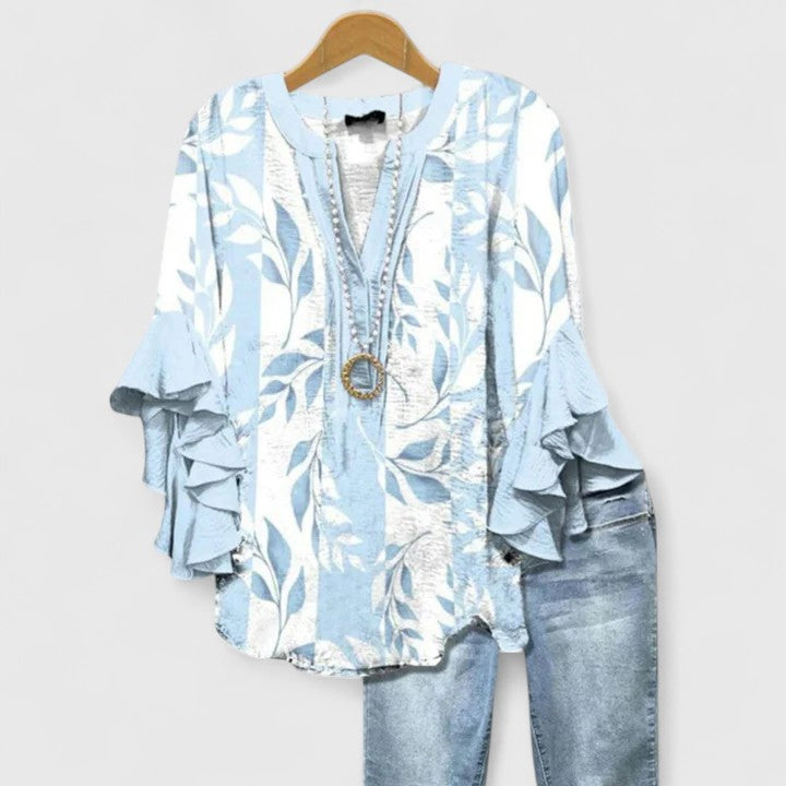 Women's summer floral top featuring comfortable fabric & playful ruffle sleeves. Ideal for elegant casual chic outfits.