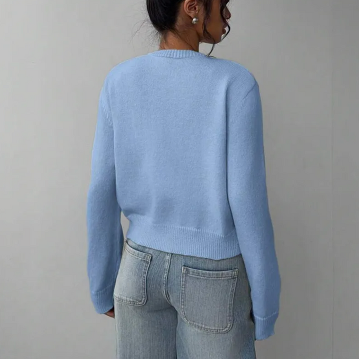 Orange women's cropped knitted button-front cardigan, adding a pop of color to summer ensembles.