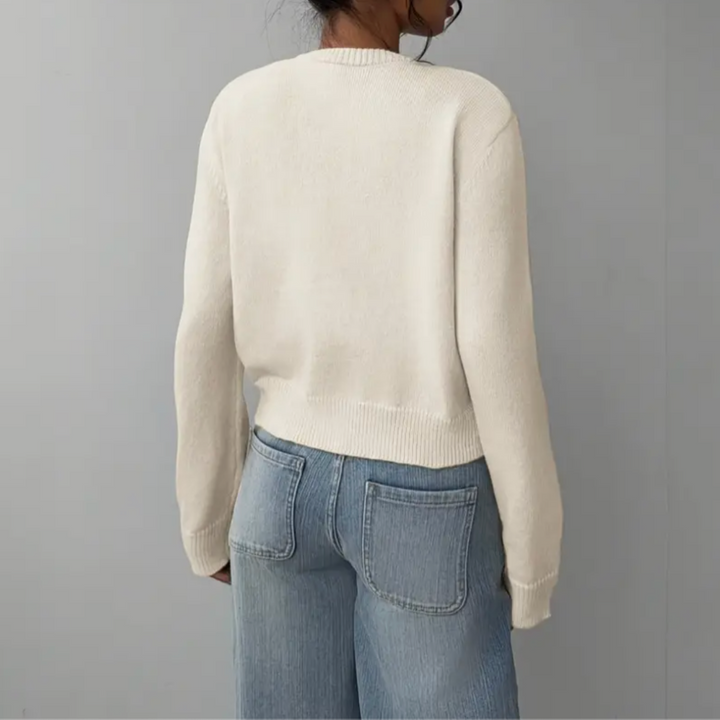 White women's cropped button cardigan paired with high-waisted jeans for a stylish spring look.