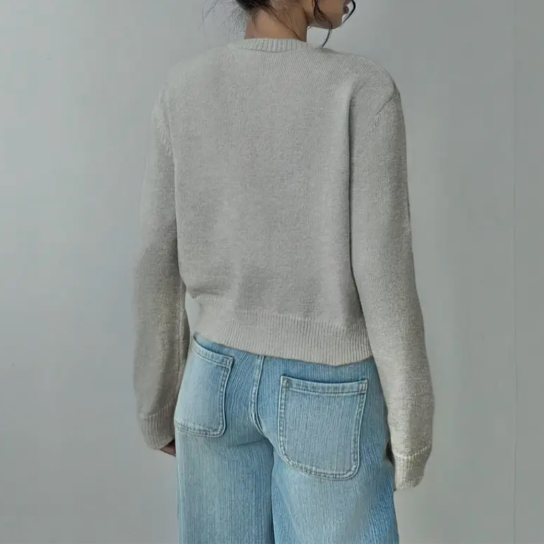 Side view of a woman in a navy cropped button cardigan, demonstrating its versatile design.