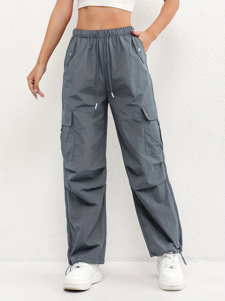Chic women's cargo parachute pants in relaxed fit, ideal for street style. Drawstring waist & adjustable hem.