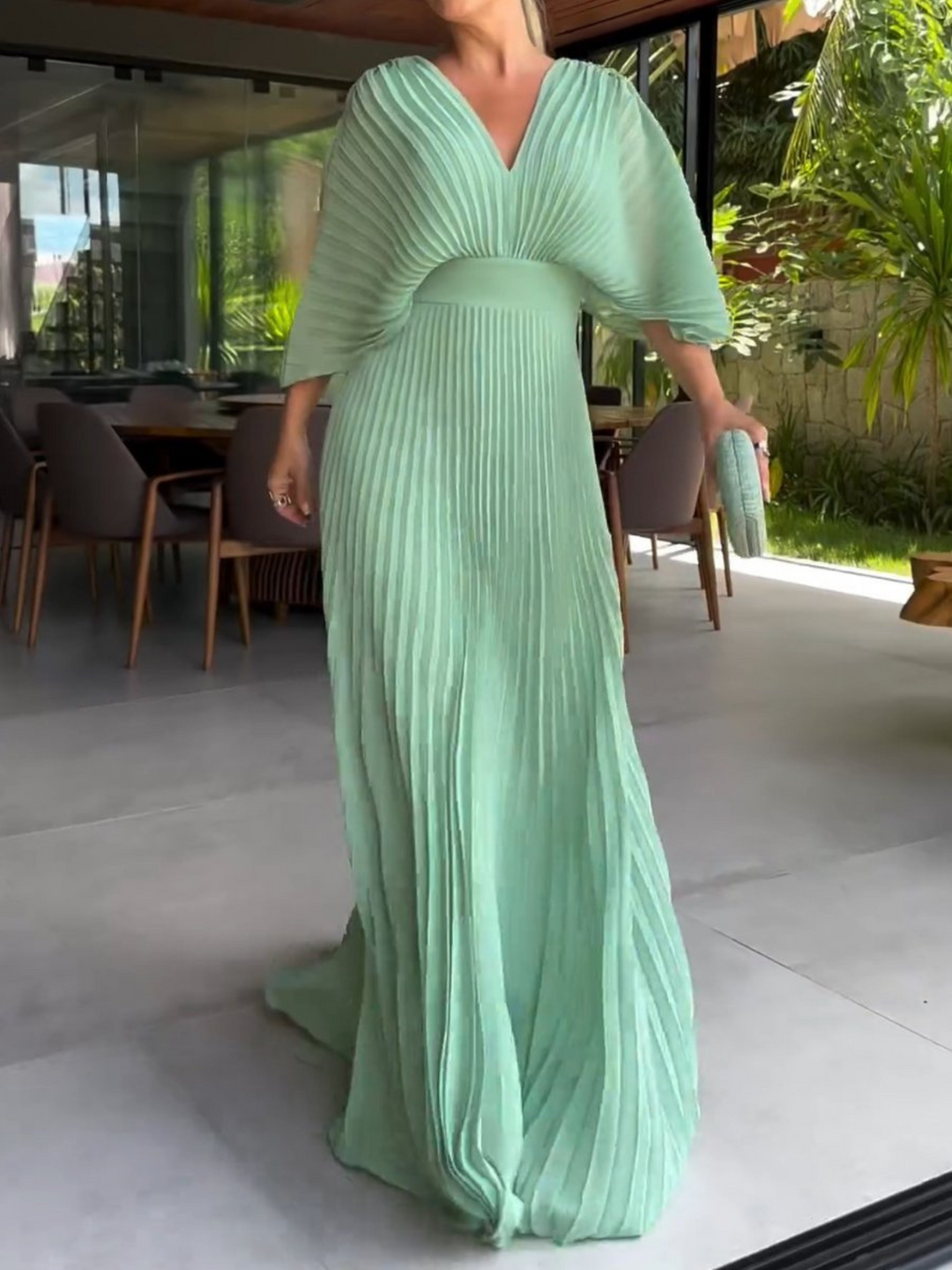 Formal women's long pleated dress featuring elegant batwing sleeves, a perfect wedding guest outfit.