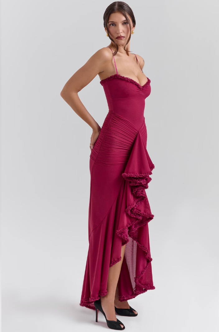Close-up of the dovetail hem and ruffle detailing on a women's elegant ruched lace dress, feminine style.