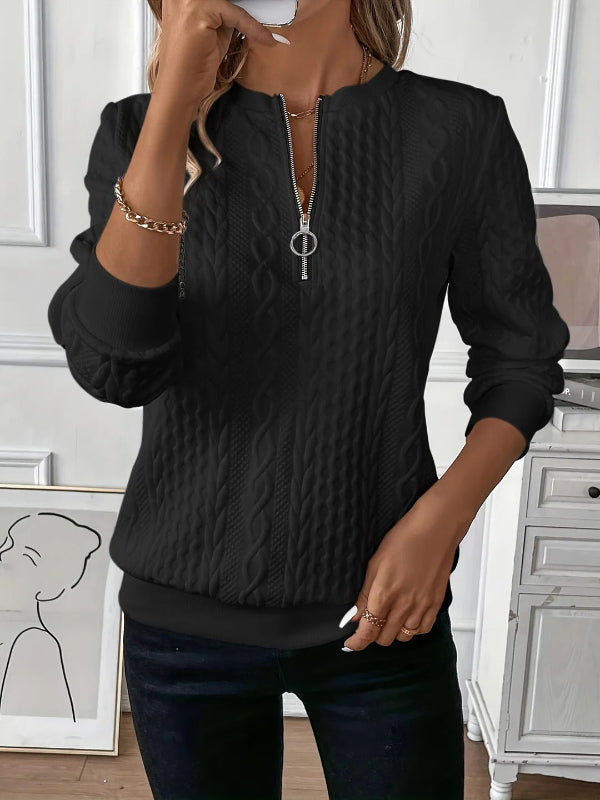 Close-up of the half-zip detail on a women's elegant spring pullover top, showing quality craftsmanship.