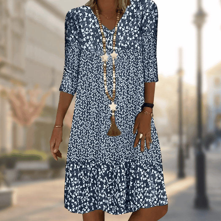 Women's flowy floral print tiered summer dress with V-neck, three-quarter sleeves, perfect for casual wear.