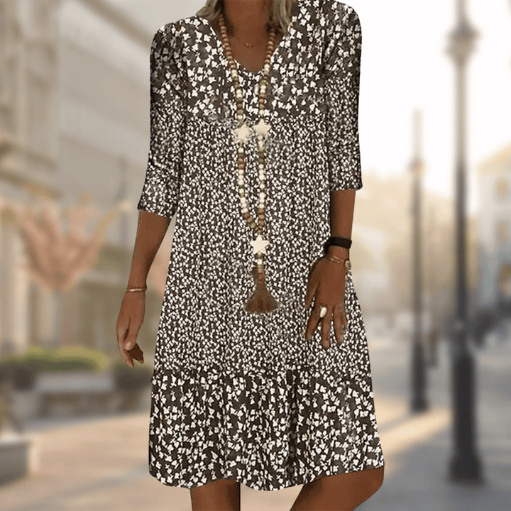 Casual women's tiered floral summer dress with flowy fabric, V-neck, and three-quarter sleeves for ultimate comfort.