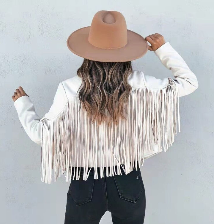 Close-up of fringe detail on a women's brown suede moto jacket, stylish leather outerwear
