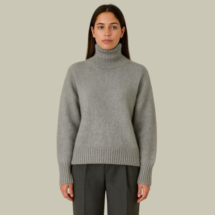 Women's high neck relaxed fit merino wool sweater in a neutral tone, showcasing its soft texture.