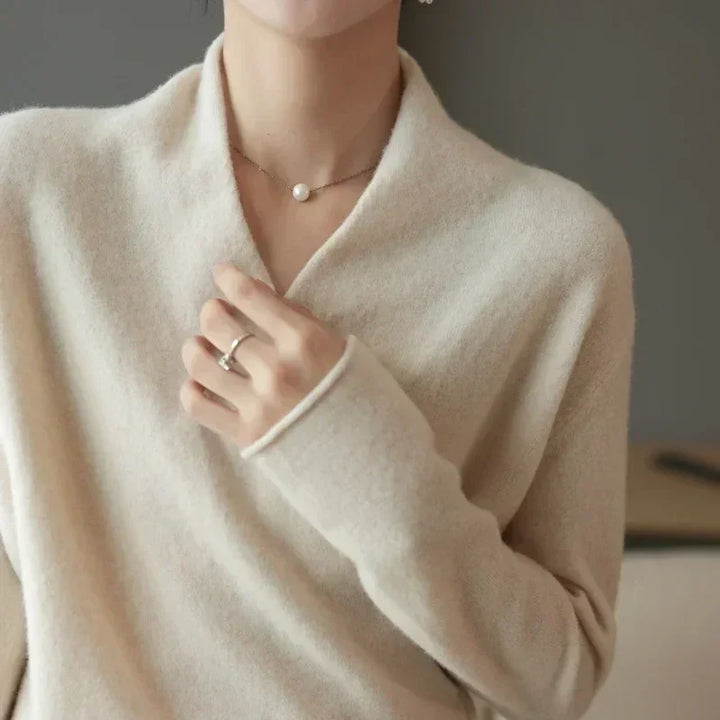 Detailed view of the wrap neck design on a women's long sleeve spring top, elegant knitwear