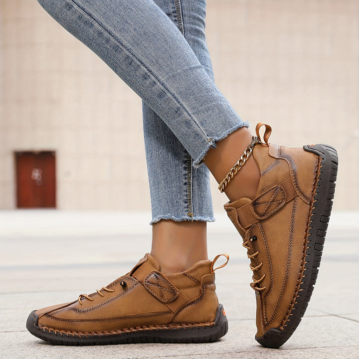 Adjustable lace-up women's flat sneakers, detailed with decorative stitching for a unique, everyday look.
