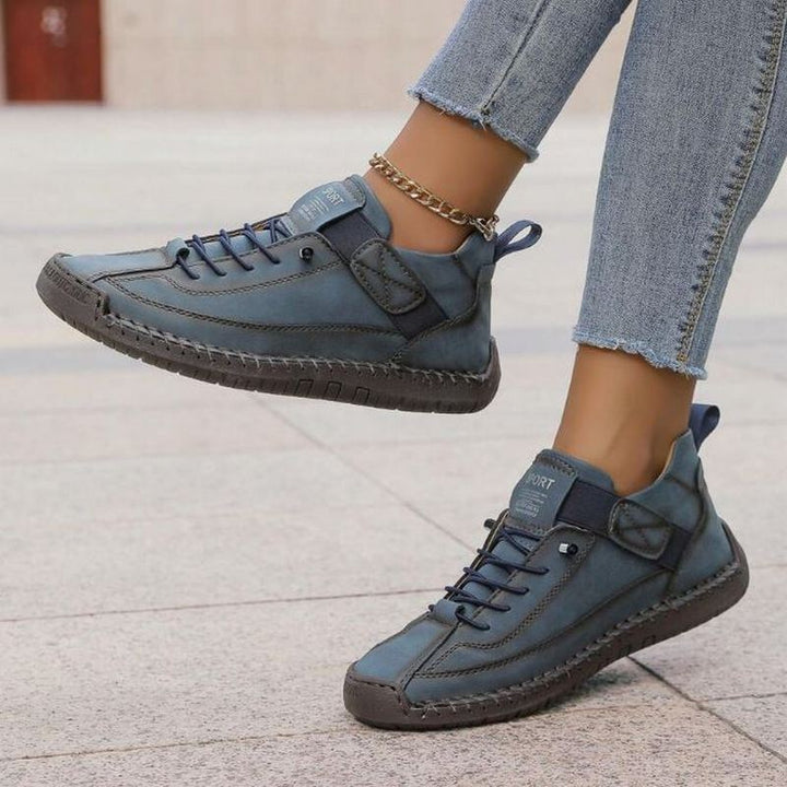 Versatile women's lace-up flat comfort sneakers, ideal for walking. Features unique decorative stitching & adjustable fit.