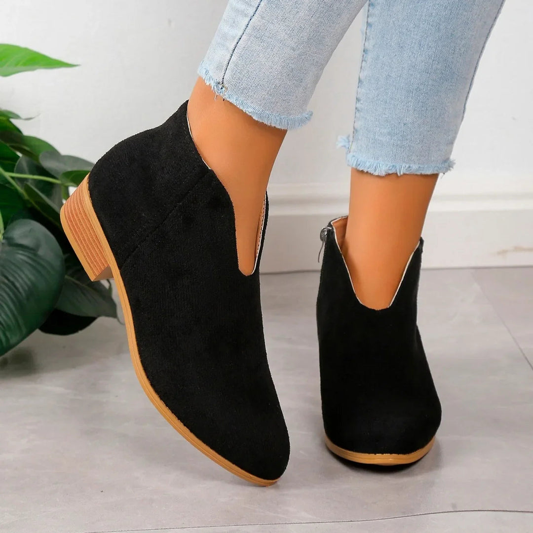 Side view of a women's leopard print ankle boot, highlighting the chunky heel and elegant design.