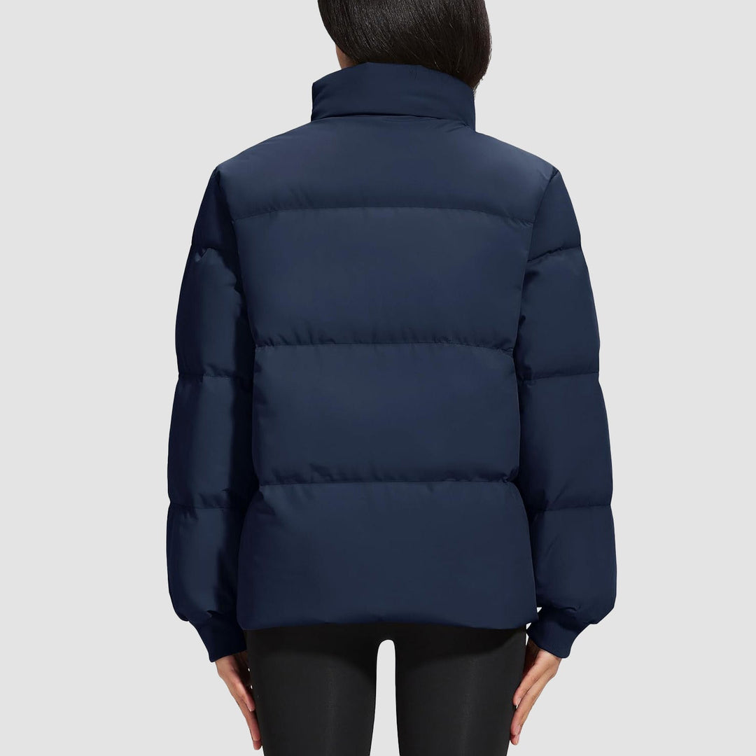 Woman running outdoors in a black quilted puffer jacket, active and protective outerwear