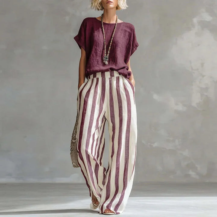 Woman in comfortable, loose cotton-linen striped two-piece summer outfit, perfect for warm casual wear.