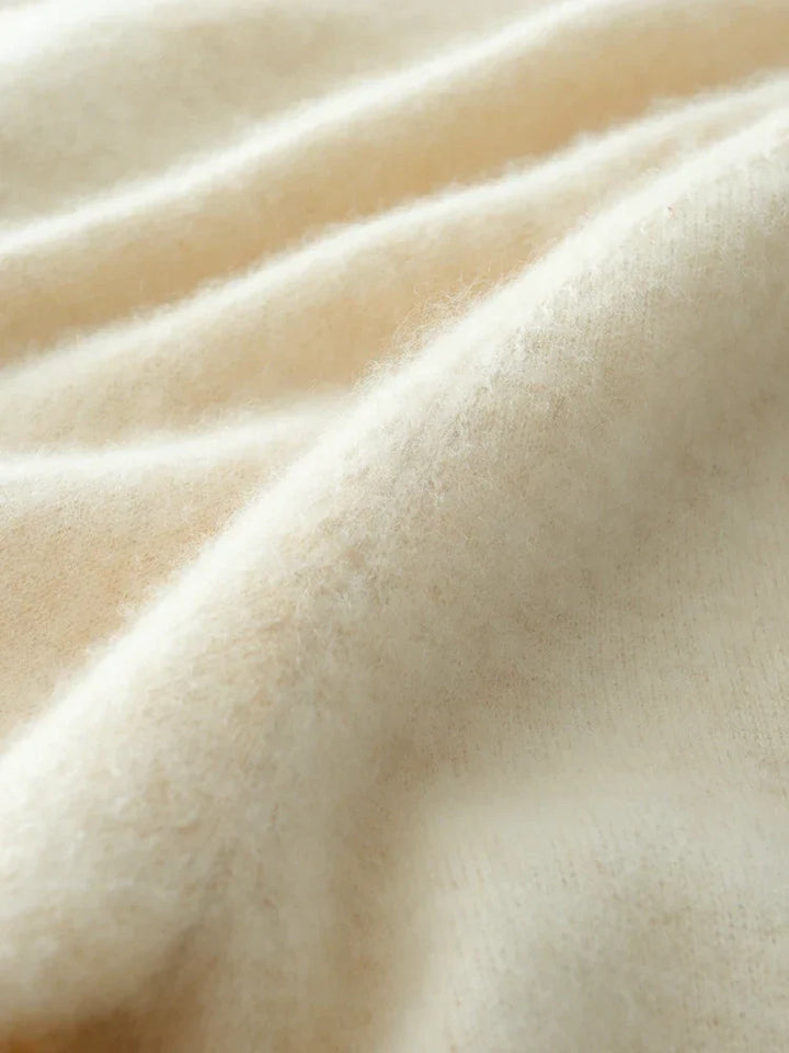 Close-up on the intricate knit pattern of the Women's Luxe Cashmere Crossover Sweater, a cozy top