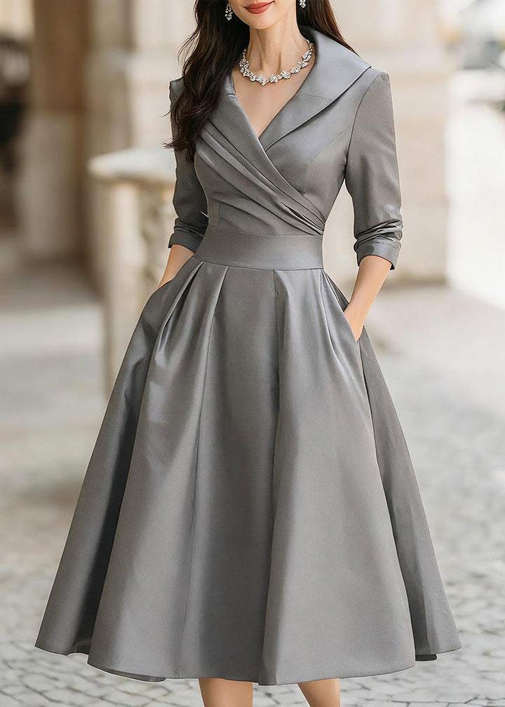 Close-up of a women's midi dress showing its chic draped collar, A-line style & discrete functional pockets.