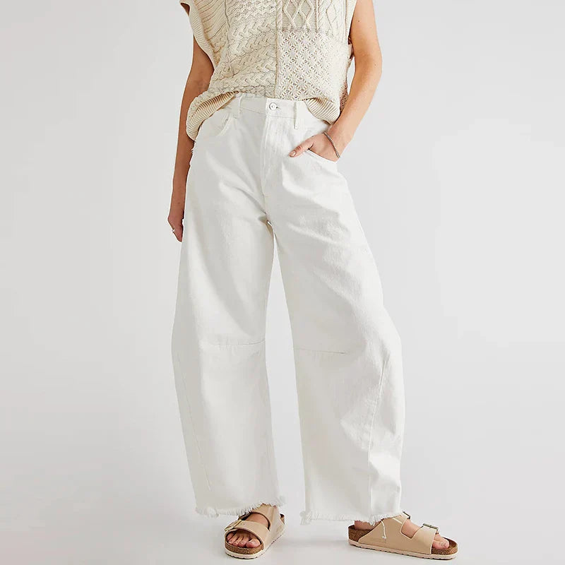 Front view of women's organic loose fit high-rise straight leg jeans, light wash denim, frayed hem.