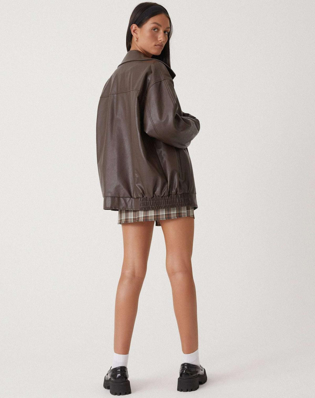 Close-up of the faux leather texture on a women's oversized bomber jacket, showcasing its quality.