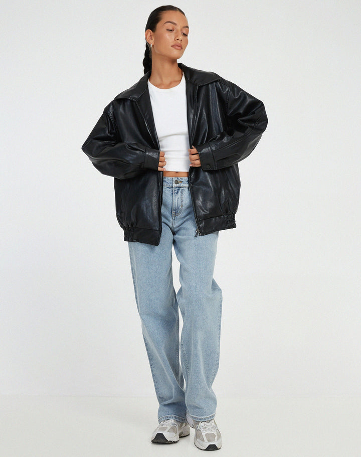 Model wearing a black oversized faux leather bomber jacket, styled casually for an everyday look.