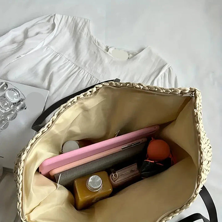 Roomy women's straw tote bag, an essential oversized beach and travel companion for summer.
