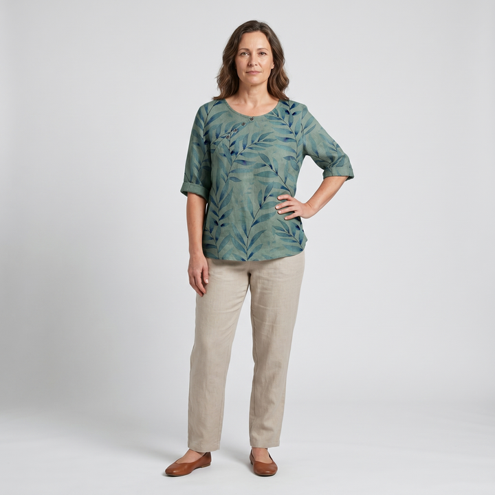 Stylish women's blouse with elegant leaf print and unique asymmetric button detail.