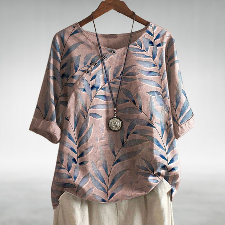 Blue women's printed top featuring a stylish leaf design & trendy asymmetric buttons.