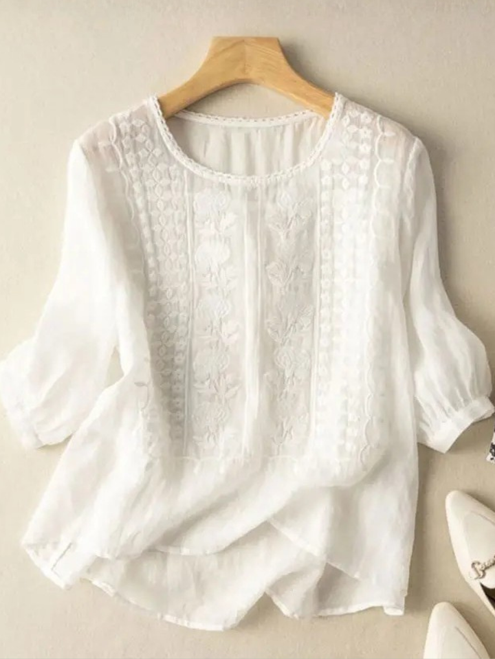 Women's relaxed fit blouse with elegant embroidery, round neck, and three-quarter sleeves for casual or stylish wear.